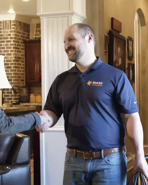 Uniformed Alco Air technician greeting homeowner, from Alco Air Cooling, Heating and Plumbing’s own photographs.