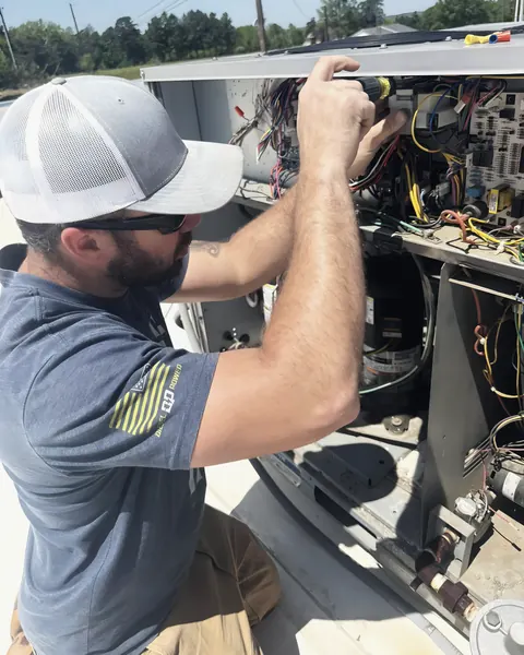 Technician servicing HVAC unit, from L&L Mechanical Services’s own photographs.