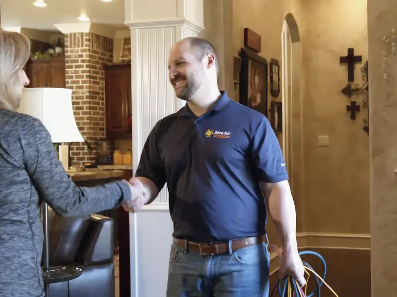 Uniformed Alco Air technician greeting homeowner, from Alco Air Cooling, Heating and Plumbing’s own website.