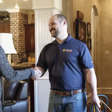 Uniformed Alco Air technician greeting homeowner, from Alco Air Cooling, Heating and Plumbing’s own photographs.