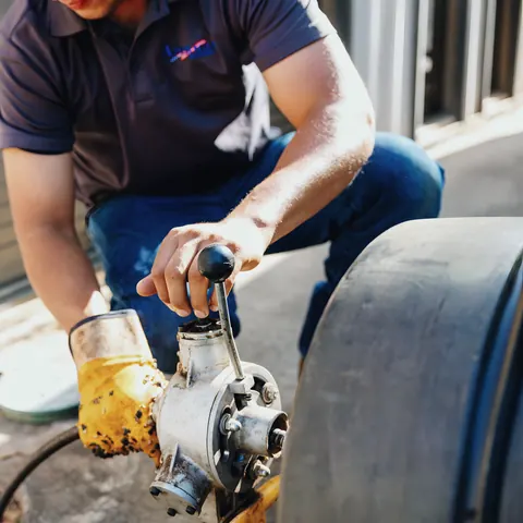 Technician using drain/sewer machine on job, from American Plumbing Co.’s own photographs.