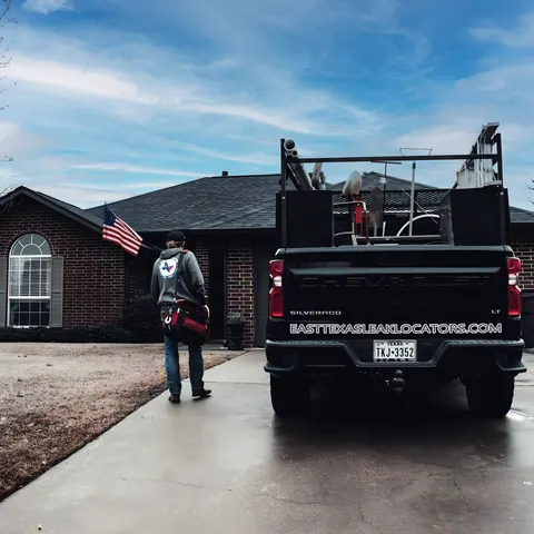 Technician walking to job with branded company truck, from East Texas Leak Locators & Plumbing Services’s own photographs.