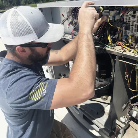 Technician servicing HVAC unit, from L&L Mechanical Services’s own photographs.