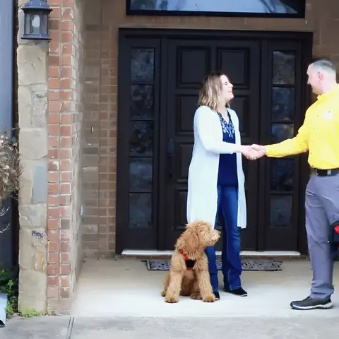 Uniformed technician greeting homeowner at the door, from Rub-A-Dub Plumbing’s own photographs.